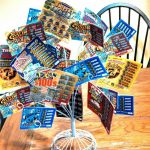 A bunch of lottery tickets in a wire holder fanned out like a bouqet of flowers